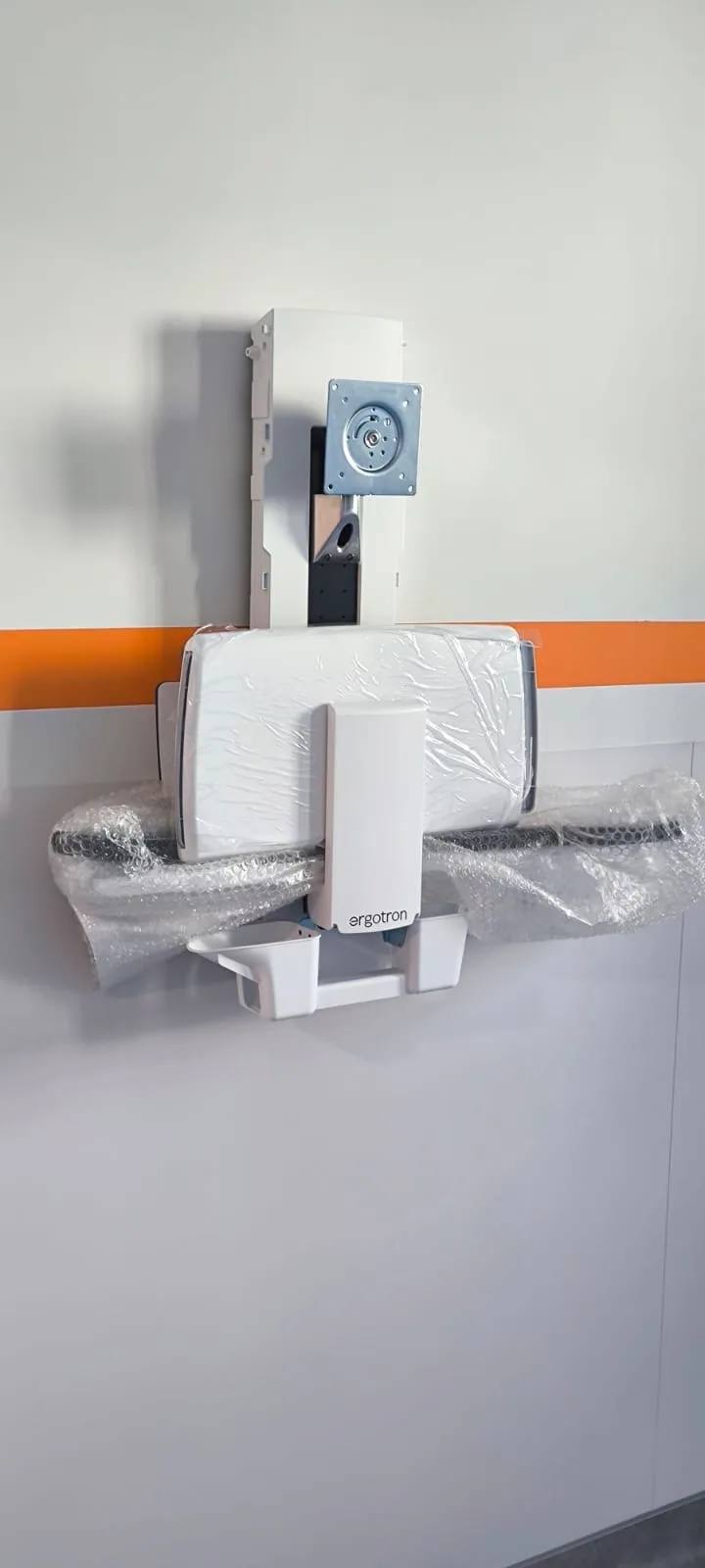 Bras articulé Ergotron fixé au mur, encore sous film de protection