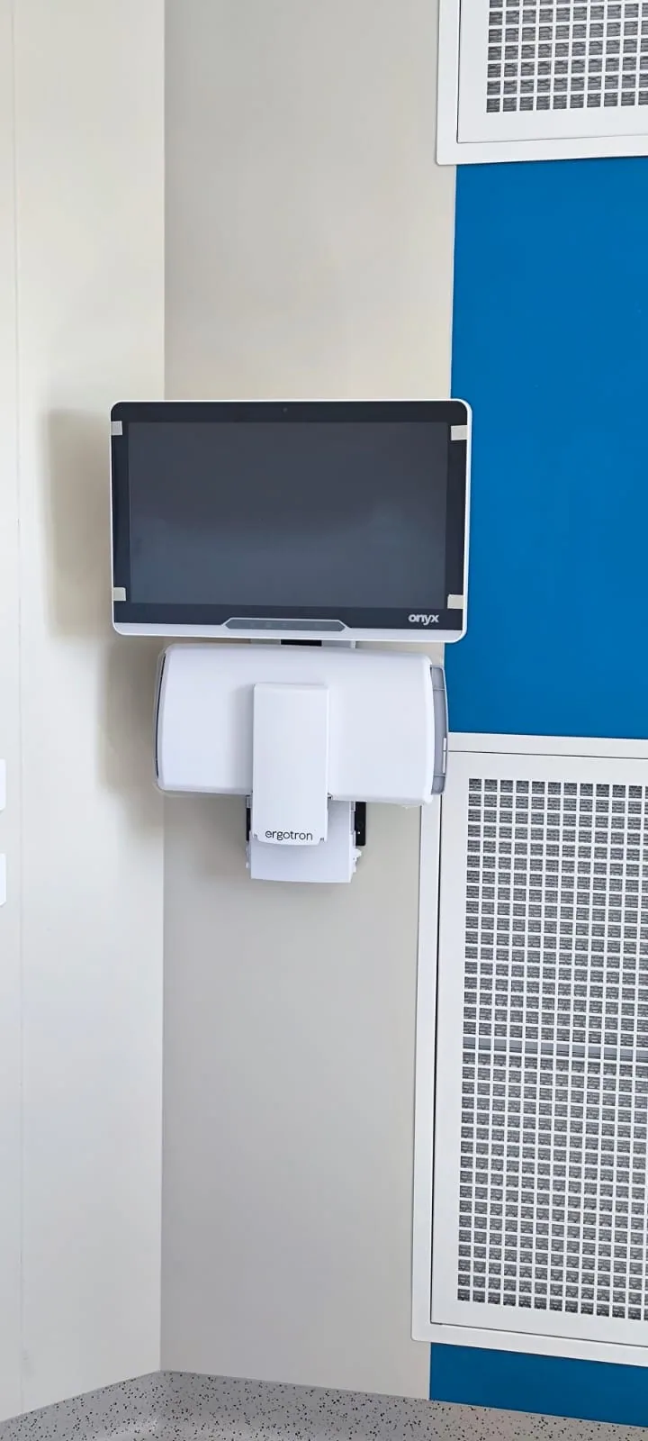 Poste Onyx sur bras Ergotron, replié à plat contre le mur